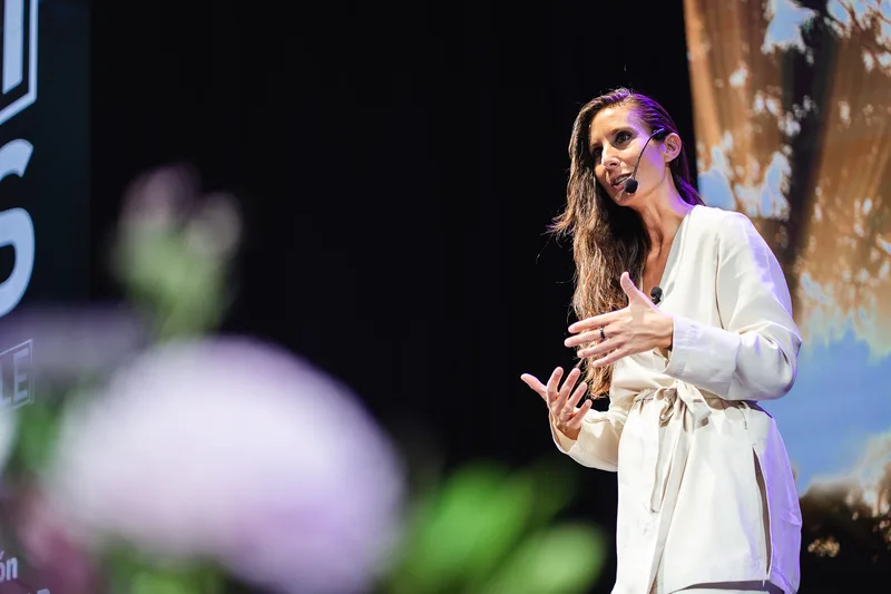 Ana Pedroche durante una conferencia, gesticulando sobre el escenario